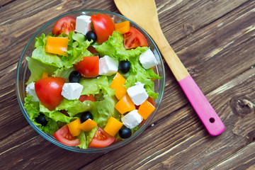 Fresh healthy greek salad on wooden table.