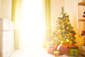 Christmas tree with gifts in a white room. Christmas morning