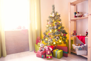 Christmas tree with gifts in a white room. Christmas morning