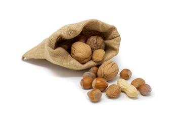 frutta secca esce da un sacco di juta su uno sfondo bianco