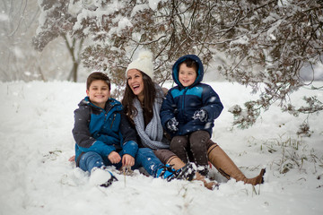 Beautiful family photo of mom with her two sons enjoying winter time.