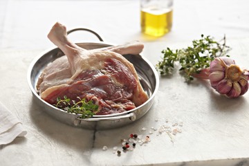 Raw duck legs. Poultry meat ready to cook on a marble cutting board.