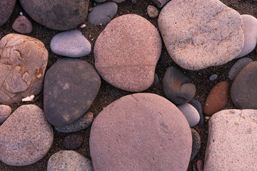 Large pebbles or stones lie on the shore at sunset. Black Sea