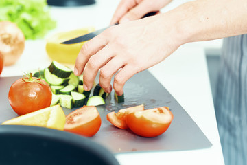 Obraz na płótnie Canvas woman cutting vegetables in the kitchen