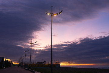 Beautiful sunset on the promenade of Batumi, Georgia. Lanterns illuminate the promenade