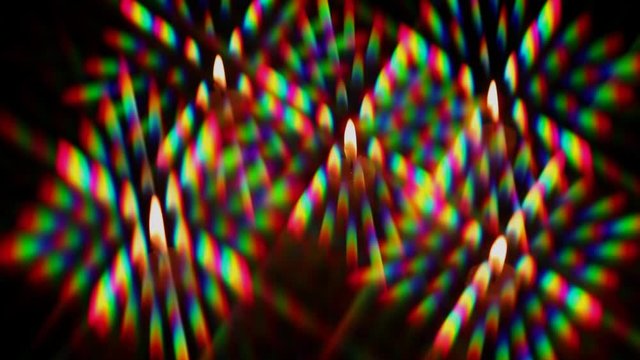 Diffraction of light from a candle flame as a set of diffraction orders, obtained using two crossed  diffraction gratings. The flame oscillates under the blow of air movement