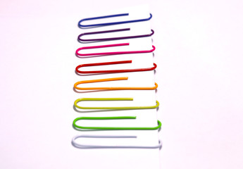 Colorful paper clips arranged in a row. Stationery.  Selective focus.side view