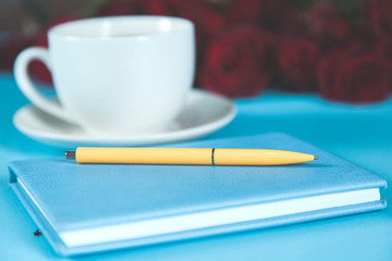 pen on notepad with red roses