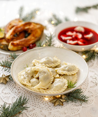 Christmas dumplings (pierogi) stuffed with forest mushrooms and cabbage on a white plate on a white...