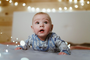the baby begins to crawl and looks up in surprise looking up at the world with clean eyes