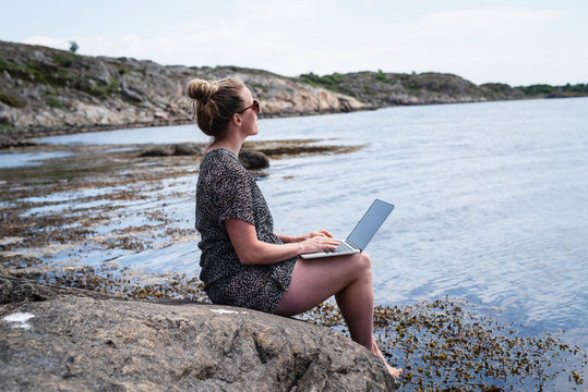 Woman using laptop at sea