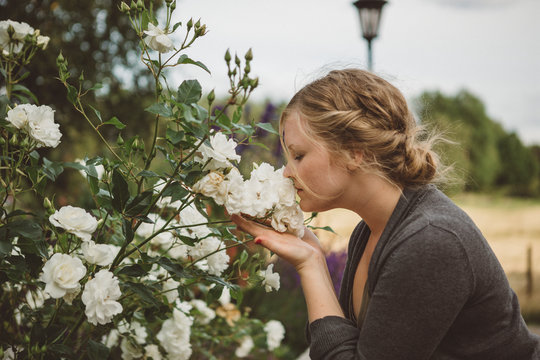 Woman smelling white flower