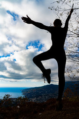 Young woman is practicing yoga. Traveling in the mountains. Yoga concept. Meditating on sunrise mountain peak.