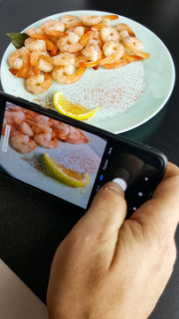 take a picture of food on a black background. a blogger is running an overview of the restaurant concept. Fresh delicious boiled peeled shrimp.