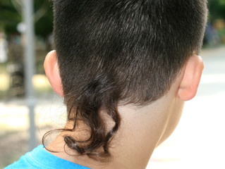Hairstyle for a boy from behind an extended strand of hair.