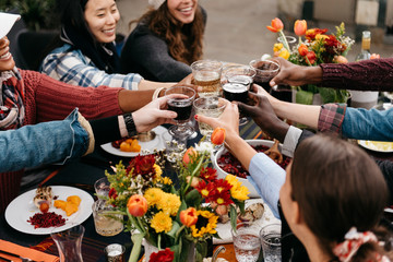 Friends toasting over a fall outdoor dinner table