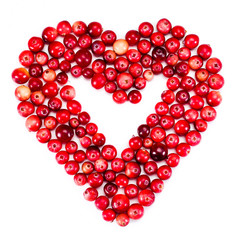Heart made of ripe cranberries isolated on a white background. Top view.
