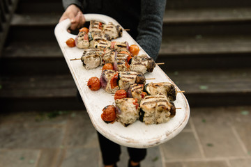 Woman presenting a chicken kabob dinner platter