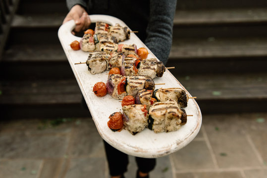 Woman presenting a chicken kabob dinner platter