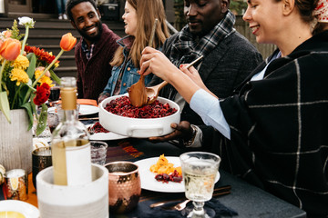 Friends serving dinner during outdoor party