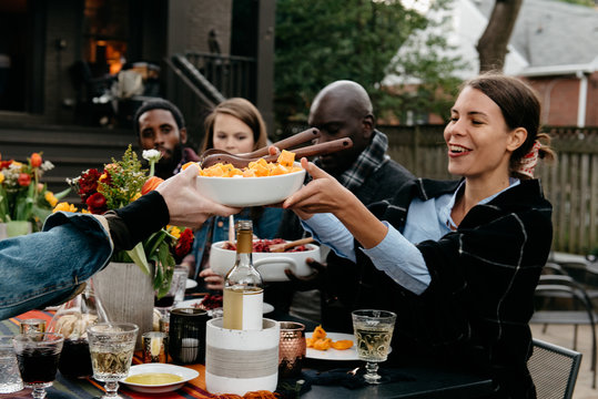 Friends serving dinner during outdoor party