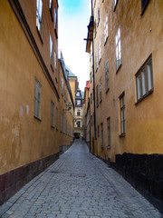 Stockholm Old Town Alley with cobblestone street and yellow stucco buildings