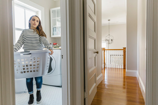 Teenager Carrying Laundry Basket at Home