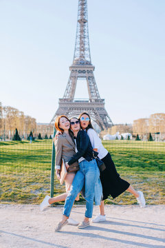 Three young woman having fun in front of the Eiffel tower
