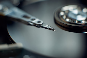 Disassembled hard disk. Read head, magnetic disk and spindle close-up.