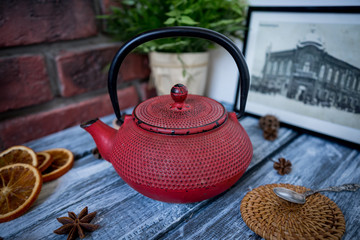 Red cast iron vintage teapot close up on vintage wood and brick surface