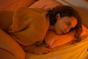 portrait of a beautiful girl on a pillow under the warm light of a lamp