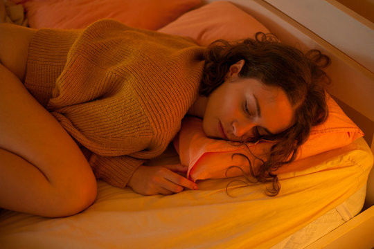 portrait of a beautiful girl on a pillow under the warm light of a lamp