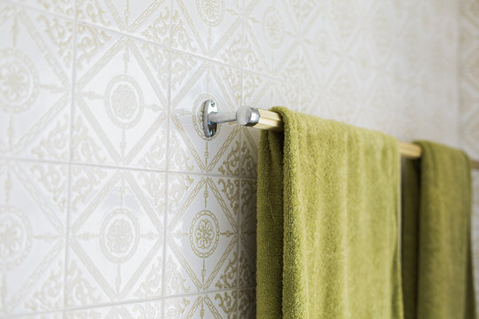 Green Towels Hang In A Retro Tiled Bathroom