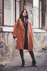 Fototapeta na wymiar Model in black dress and long brown coat. Trench. Style. Fashion trends 2020. Hair with ombre. Business lady. Blogger. Work