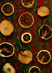 Red background with pine needles and dry oranges.