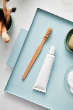 Overhead view of wooden toothbrush with toothpaste in tray