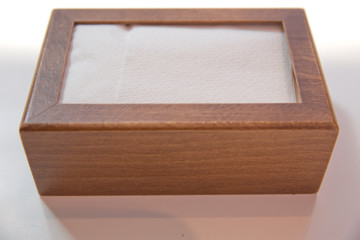 Wooden napkin holder with paper serviettes . Wooden brown empty napkin box . wooden stand with salt shaker, napkins on a wooden table in a cafe .