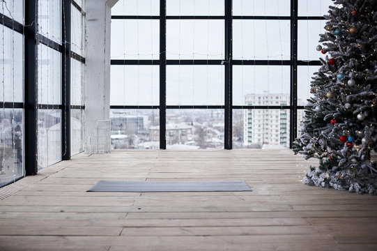 Empty Space In Fitness Center, Big Windows, Natural Wooden Floor, Modern Loft Studio, Unrolled Yoga Mat On The Floor. No People. New Year Christmass Concept