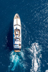 Vertical high angle shot of a private yacht and a small motorboat sailing in the ocean