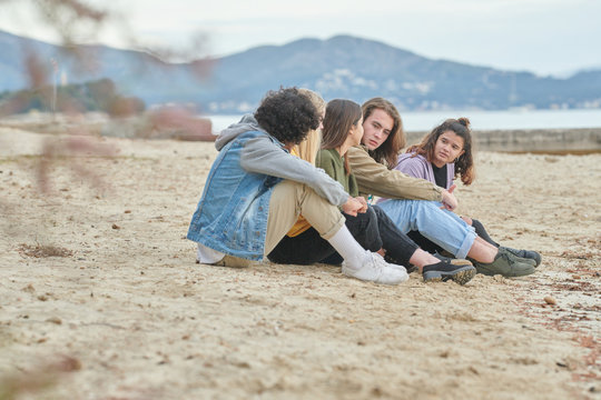 Teens chatting on the beach.