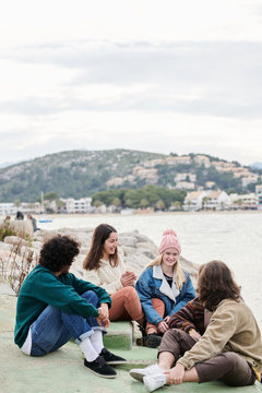 Teenage friends hanging out by sea