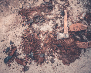 composition of an ax, earth and fragments of asphalt