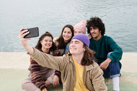 Teenage friends taking selfie on pier