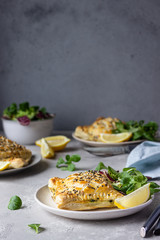 Puff pastry pie with salmon, spinach and ricotta cheese served with green lettuce leaves. Salmon Wellington in puff pastry.