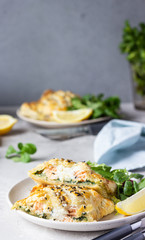 Puff pastry pie with salmon, spinach and ricotta cheese served with green lettuce leaves. Salmon Wellington in puff pastry.