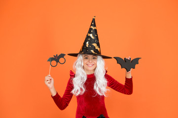 Photo booth props. Little child in witch costume. Magical spell. Small witch with white hair. Wizard or magician. Halloween party. Small girl in black witch hat. Autumn holiday. Join celebration