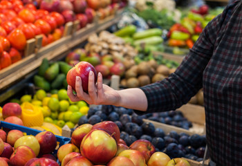 Caucasian girl buying fresh vegetables food products at the market.