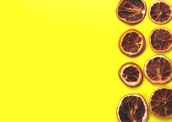 Slices of Dried oranges on yellow background. New Year or Christmas card.