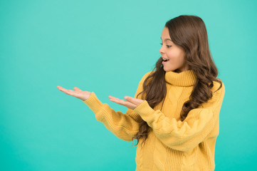 Look here copy space. Positivity concept. Emotional baby. Positive child. Positive attitude to life. Positive mood. Kids psychology. Adorable smiling girl wear yellow sweater turquoise background