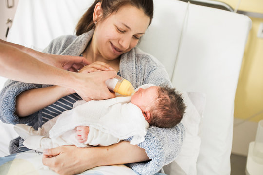 Mother getting help from the nurse bottle feeding her baby